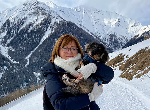 Madlaina mit Dackeldame auf dem Arm vor den Engadiner Schneebergen